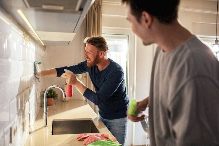 Deux hommes nettoyants leurs cuisines pour le grand ménage de printemps